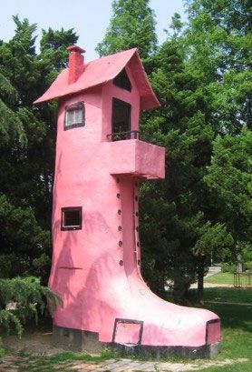 a pink house shaped like a slide in the park