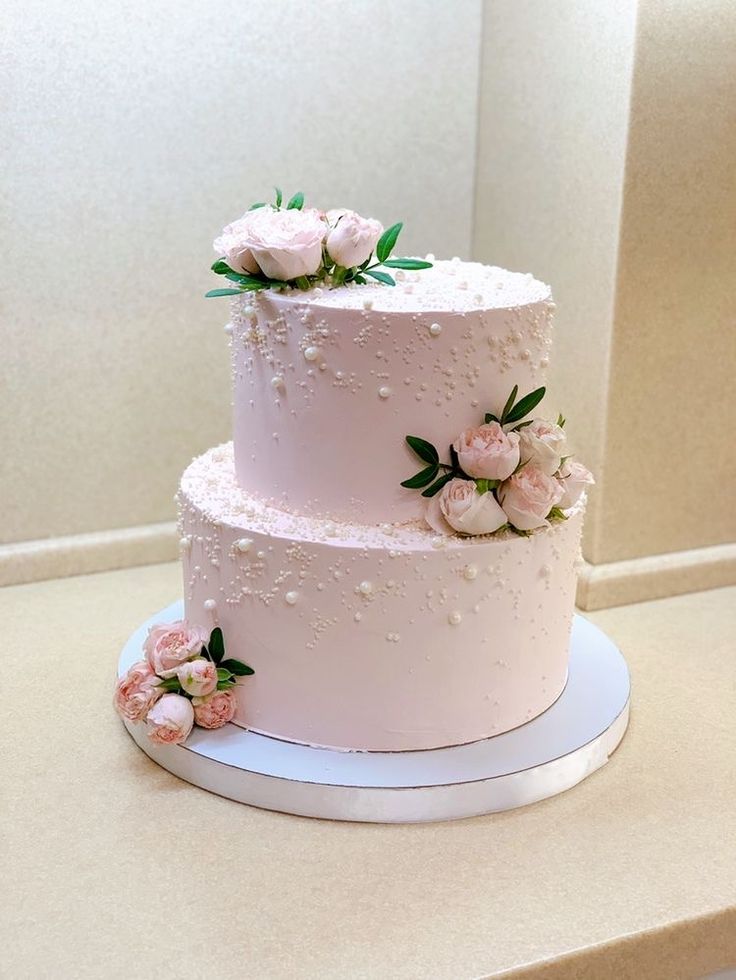 a three tiered cake with pink flowers on top