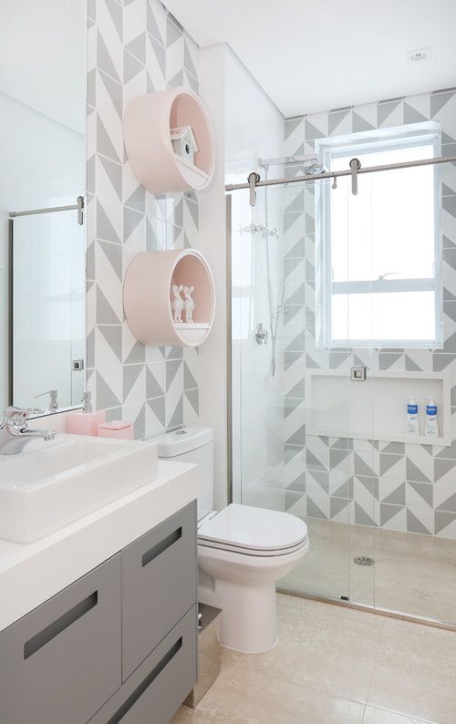 a bathroom with grey and white tiles on the walls