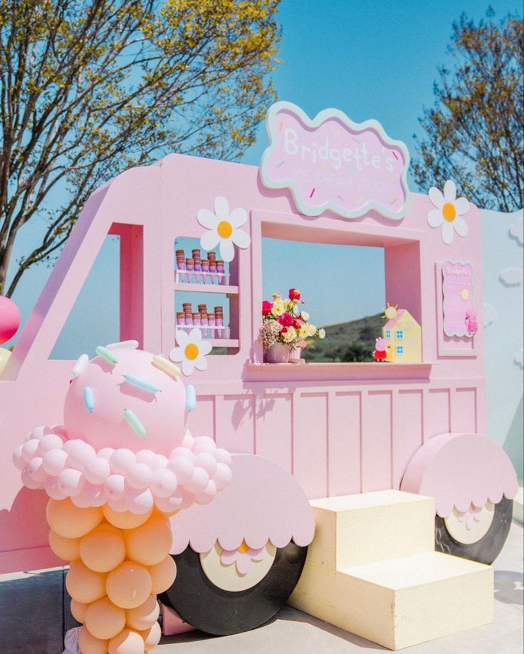 a pink ice cream truck with flowers on it