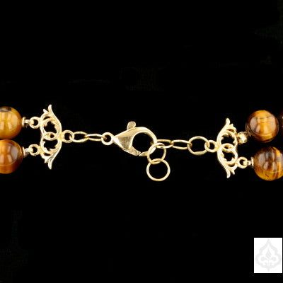 Description: This exquisite necklace is a stunning combination of Tiger eye, Ivory Netsuke Beads, and Amber with 14K Gold Findings. The necklace weighs 291.3 grams and features a variety of beads, each with its unique pattern and color. The 14K yellow gold findings add a touch of elegance and luxury to this beautiful piece of jewelry. Specifications: Bead Type: Tigereye, Ivory Netsuki Beads, Amber Metal: 14K Yellow Gold Weight: 291.3 grams Necklace Length: N/A Clasp Type: 14K Yellow Gold Item Co Luxury Handmade Double Strand Necklace, Traditional Necklaces With Natural Stones For Formal Occasions, Traditional Formal Necklaces With Natural Stones, Elegant Amber Jewelry With Polished Beads, Elegant Rondelle Beads With Natural Stones, Luxury Hand-strung Beaded Necklace With Round Beads, Double Strand Gold Pearl Necklace With Gemstone Beads, Gold Double Strand Pearl Necklace With Gemstone Beads, Luxury Beaded Necklaces