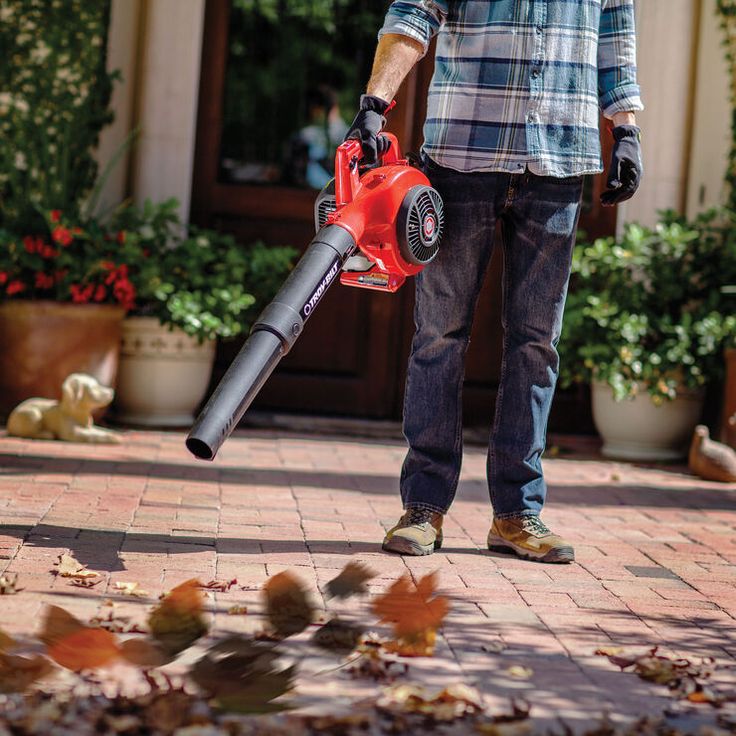 a man using a leaf blower on the ground