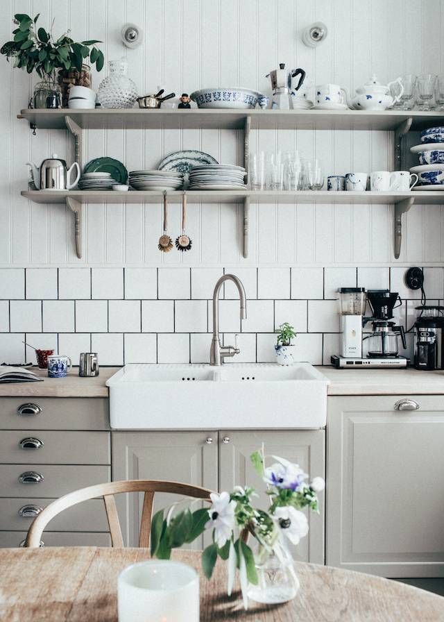 a kitchen filled with lots of white appliances and counter top next to a wooden table