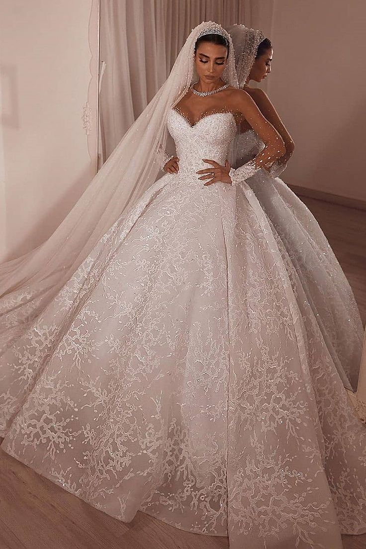 two women in wedding gowns standing next to each other