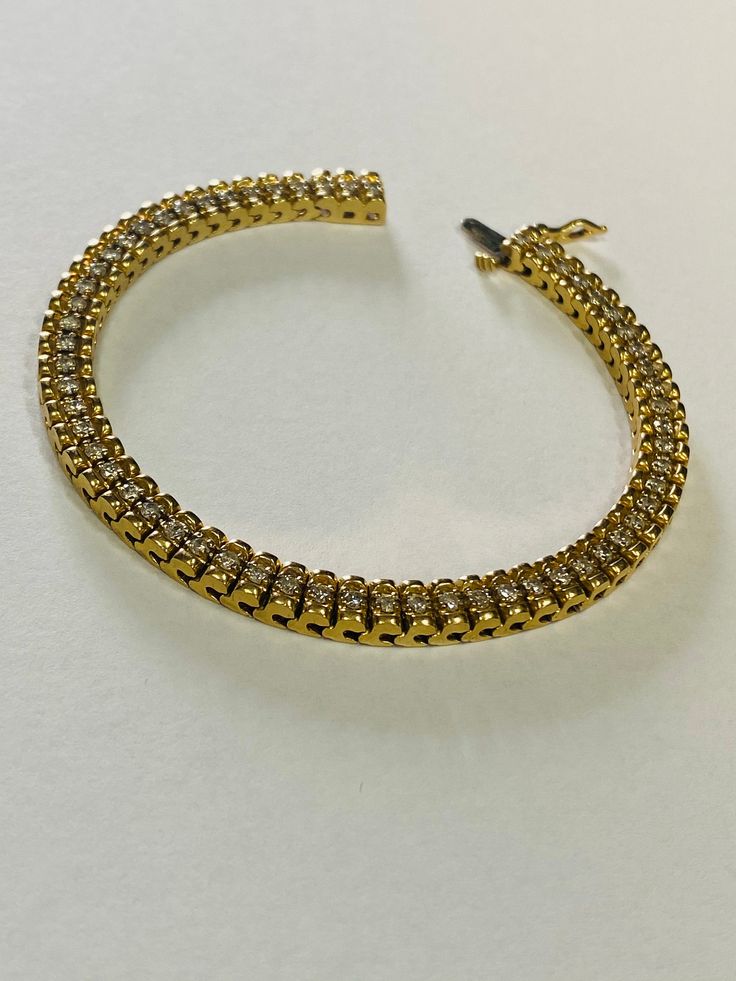 "This is an elegant 14K yellow gold and diamond tennis bracelet. Material(s): 14K yellow gold + (60) diamonds 0.03 points each (Total diamond weight: 2 carats) Weight: 21.1 grams Flaws (if any): None to mention Marking(s): \"14K\" Inside of bracelet measures 7 inches and 5.3 millimeters. If you have any questions about this diamond tennis bracelet, please do not hesitate to contact us! ♥" Formal Gold Bracelets With Diamond Accents, Yellow Gold Tennis Bracelet With Diamond Accents For Anniversary, Timeless Gold Diamond Bracelet With Accents, Anniversary Yellow Gold Tennis Bracelet With Diamond Accents, Classic Gold Diamond Bracelet, Classic Diamond Gold Bracelet, Gold Diamond Cut Bracelet - Timeless Style, Timeless Gold Diamond Cut Bracelet, Gold Tennis Bracelet For Anniversary