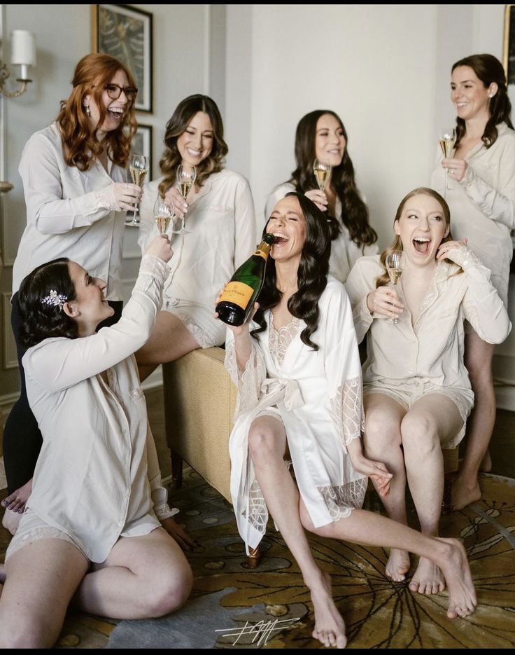 a group of women sitting around each other drinking champagne