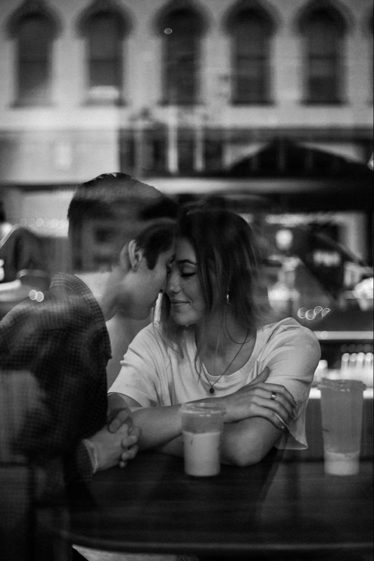 two people sitting at a table with drinks