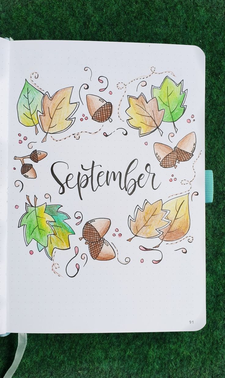 an open notebook with autumn leaves and the words september written on it in black ink