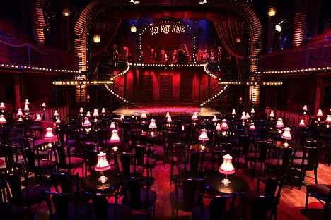 an empty stage with lots of tables and chairs