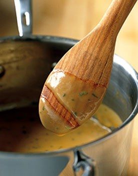 a wooden spoon in a pot filled with soup