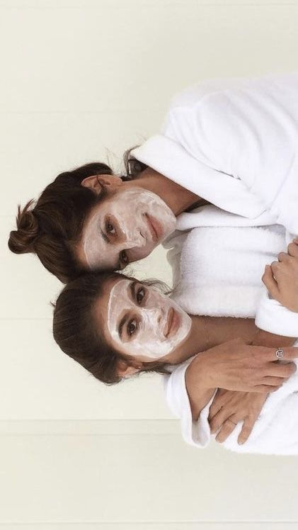 two women are wrapped in white towels and have facial masks on their faces as they pose for the camera