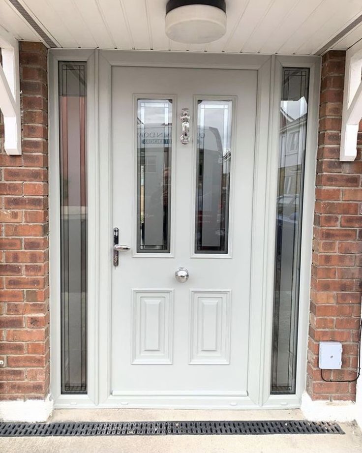 a white front door with two sidelights and glass panels on the outside of it