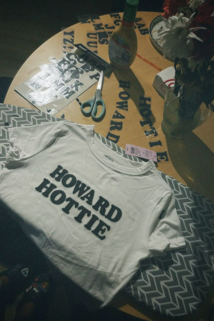 a t - shirt that says howard hottie on it next to scissors and flowers