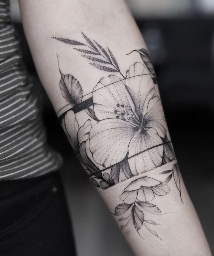 a black and white flower tattoo on the arm