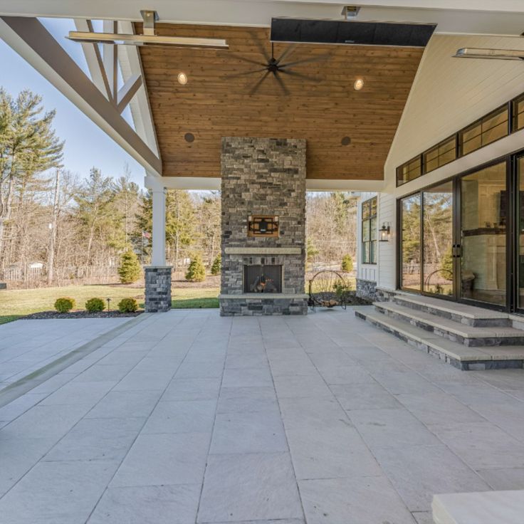 an outdoor patio with stone fireplace and seating area