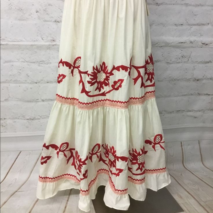 Long Skirt With Beautiful Embroidery And Red Trim. Bohemian White Full Skirt Bottoms, Embroidered Hem Flowy Long Skirt, White Embroidered Maxi Skirt For Spring, White Floral Embroidered Tiered Skirt, Traditional Red Flared Maxi Skirt, White Flared Skirt With Floral Embroidery, White Floral Embroidered Skirt, White Embroidered Full Skirt, Traditional Red Bottoms For Spring