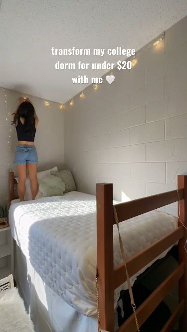 a woman standing on top of a bed in a room with lights strung from the ceiling