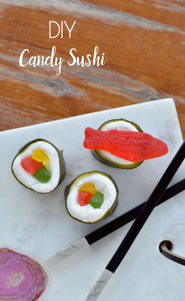 some sushi on a white plate with chopsticks next to it and the words diy candy sushi