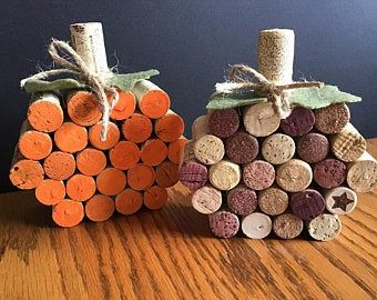 two pumpkin shaped wine corks sitting on top of a wooden table