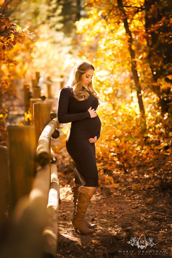 a pregnant woman is standing in the woods