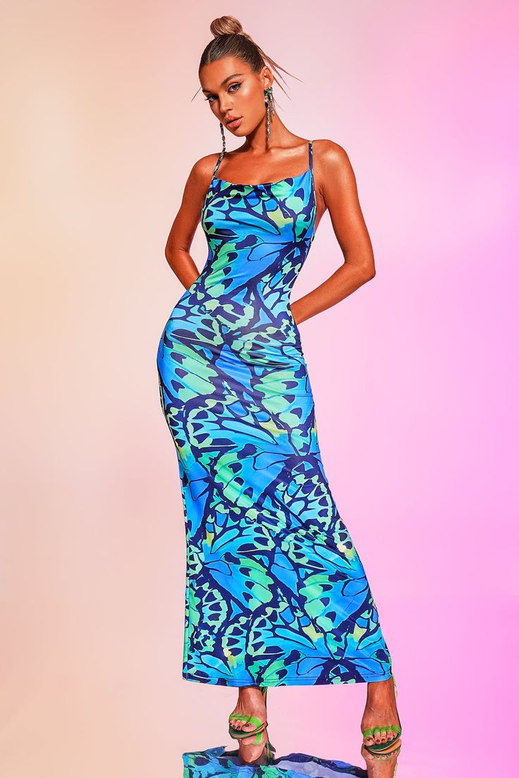 Make a statement this summer with the Sukia Printed Maxi Dress from Bella Barnett. The stunning dress features a bold, blue print that is sure to turn heads, while its lightweight and flowy fabric ensures comfort all day long. The dress also comes with adjustable straps and a open back that flatters your figure for a perfect fit. Try styling your hair in a loose bun or braids for a relaxed and effortless vibe.     Fabric composition: polyester Washing method: hand wash Model wearing size S  Mode Blue Fitted Printed Sundress, Fitted Maxi Dress With Adjustable Straps For The Beach, Blue Sundress With Straps, Blue Spaghetti Strap Dress With Adjustable Straps, Blue Sundress With Spaghetti Straps For Summer, Blue Strapped Summer Dress, Blue Sundress With Adjustable Straps For Spring, Blue Spaghetti Strap Sundress For Summer, Blue Fitted Sundress With Spaghetti Straps