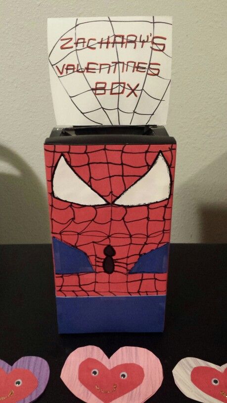 two paper hearts are placed in front of a valentine's box with spiderman on it