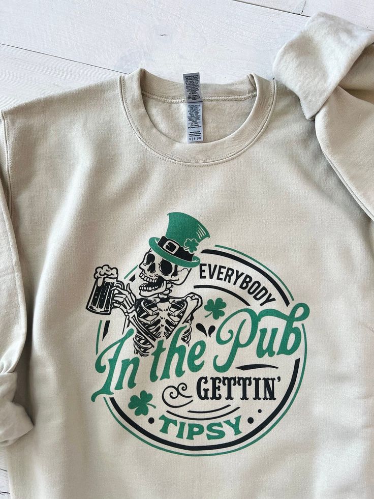 Funny St Patricks day sweatshirt, St Pattys day parade top, Everybody in the Pub Gettin Tipsy shirt, Irish crew gift, Irish drinking sweater ▬▬▬▬▬▬▬▬▬▬▬▬▬▬▬▬ DETAILS ▬▬▬▬▬▬▬▬▬▬▬▬▬▬▬▬ Our sweatshirts are SUPER soft and SUPER comfy. They do RUN BIG! Make sure to choose your size accordingly! ▬▬▬▬▬▬▬▬▬▬▬▬▬▬▬▬ FABRICATION ▬▬▬▬▬▬▬▬▬▬▬▬▬▬▬▬ 8 oz., 50% Cotton/ 50% Polyester -- Preshrunk -- Double needle stitching at shoulder, armhole, neck, waistband and cuffs ▬▬▬▬▬▬▬▬▬▬▬▬▬▬▬▬ MATERIALS ▬▬▬▬▬▬▬▬▬▬▬▬▬▬▬▬ Direct to garment printer (ink) ▬▬▬▬▬▬▬▬▬▬▬▬▬▬▬▬ CARE INSTRUCTIONS ▬▬▬▬▬▬▬▬▬▬▬▬▬▬▬▬ Machine wash Do not iron directly on letters ▬▬▬▬▬▬▬▬▬▬▬▬▬▬▬▬ PERSONALIZATION ▬▬▬▬▬▬▬▬▬▬▬▬▬▬▬▬ We absolutely love customizing orders for people! The best feeling is being able to add a personal touch to our designs Saint Patrick’s Day Outfit, Sweater Details, Funny St Patricks Day, The Pub, Christmas Catalogs, St Pattys Day, St Pattys, Printer Ink, St Patricks