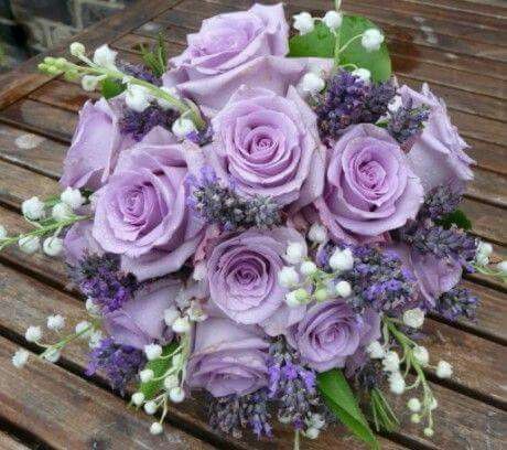 a bouquet of purple flowers sitting on top of a wooden bench