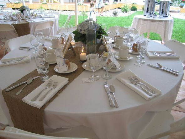 the table is set with white linens and silverware