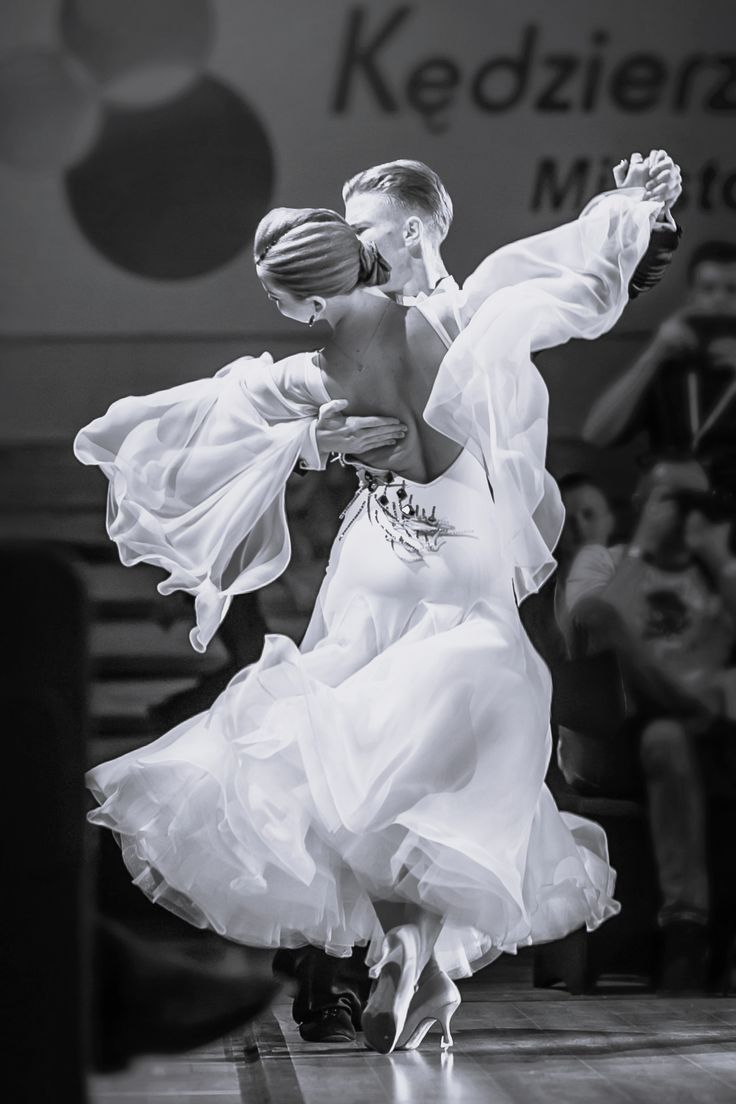 a woman in a white dress is dancing