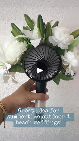 a person holding a fan with flowers in it and the words great idea for summertime outdoor & beach wedding