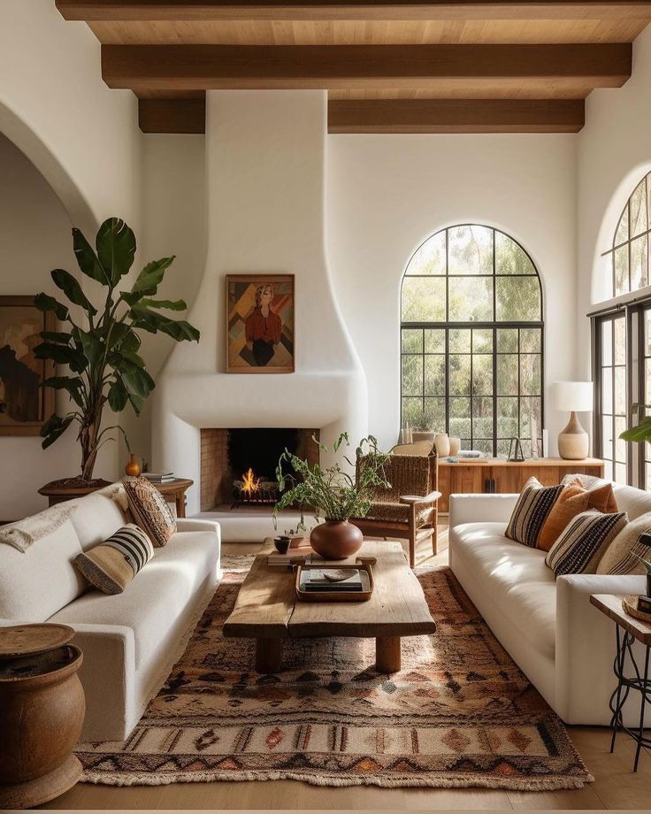 a living room filled with furniture and a fire place in the middle of a room