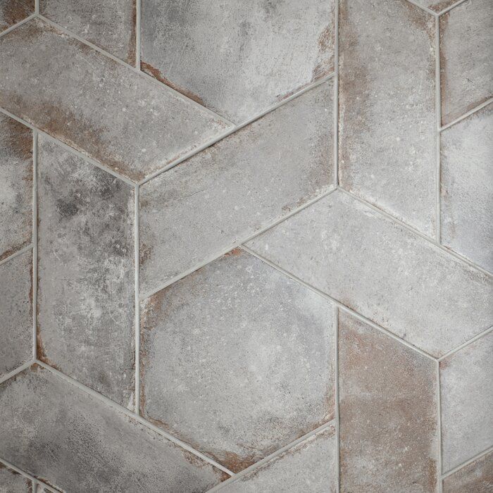 a close up view of a tile floor with grey and white colors on the tiles