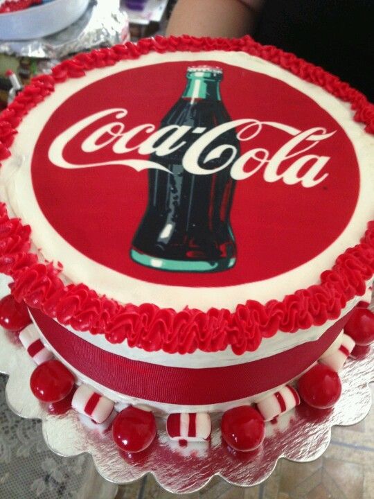 a coca - cola cake with red and white frosting on top, decorated with candy canes