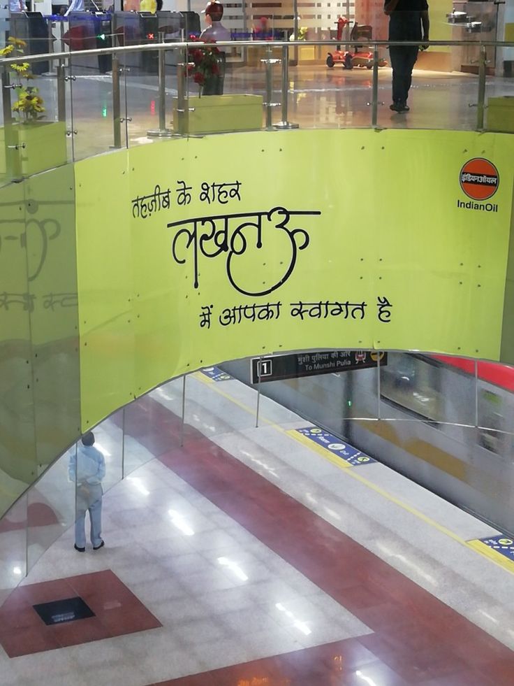 a man standing in front of a yellow sign with writing on it at an airport