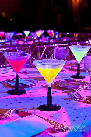 many different colored drinks are sitting on the table with silverware and napkins in front of them