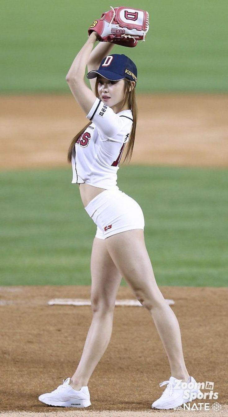 a woman in white uniform holding a catchers mitt over her head on a baseball field