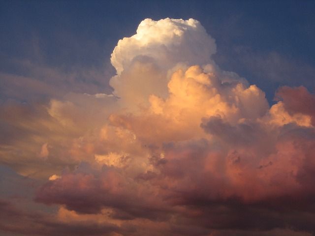 a large cloud is in the sky at sunset