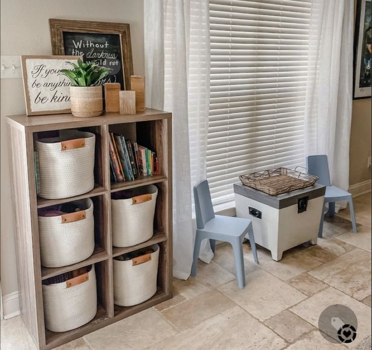 a room with several storage bins and chairs in front of a window that has white blinds