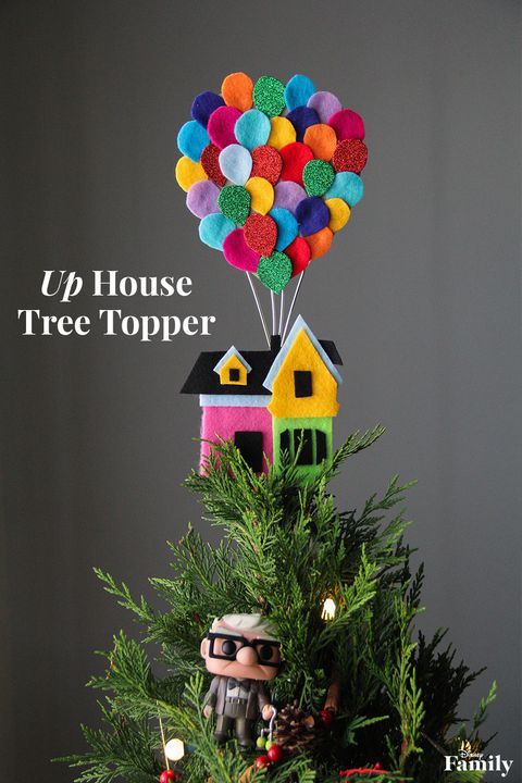 a small christmas tree with balloons on top and the words up house tree topper above it