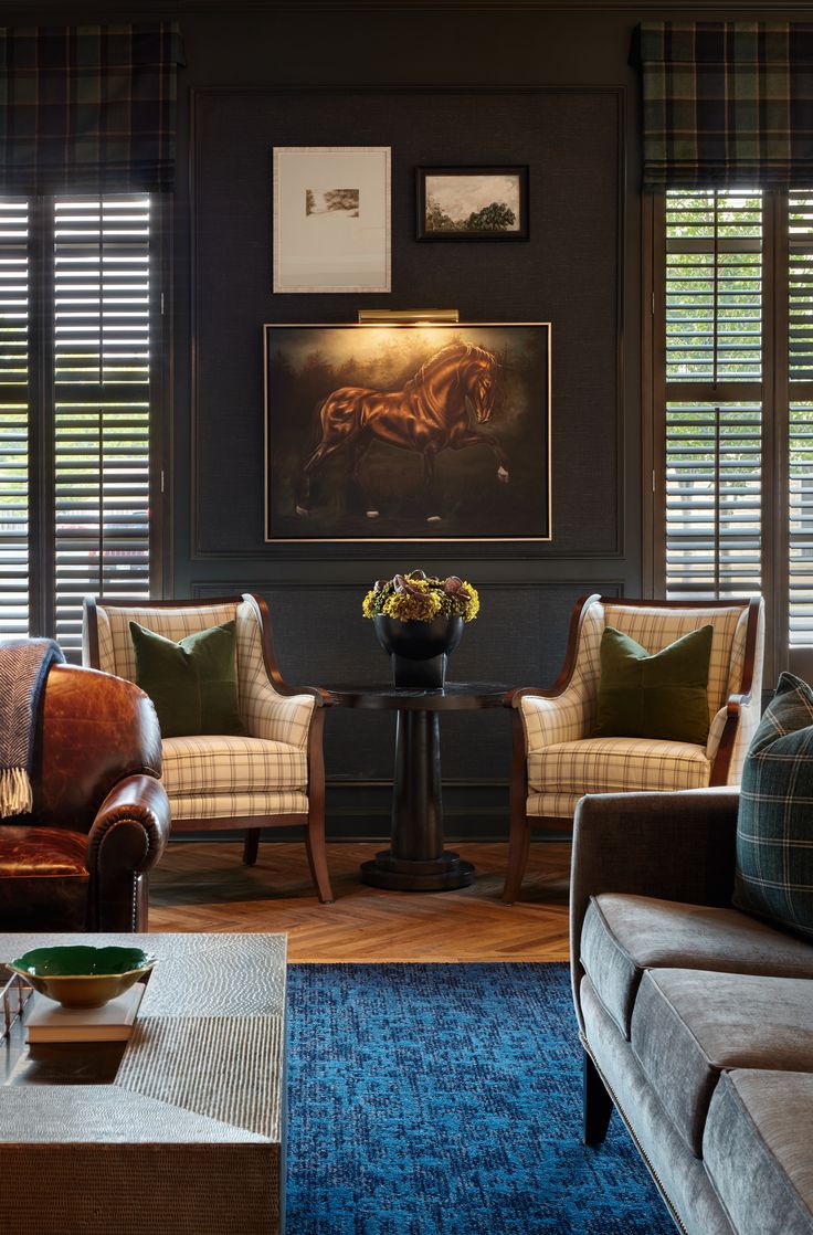 a living room with two couches, chairs and a table in front of windows