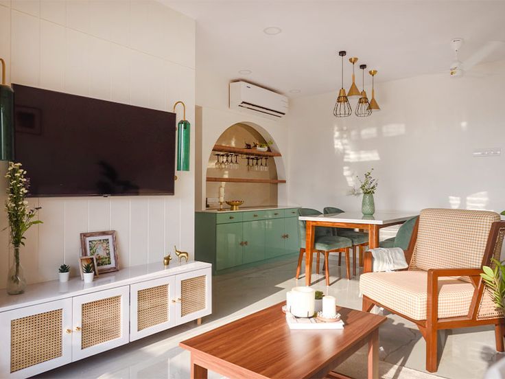 a living room filled with furniture and a flat screen tv mounted on a wall above a wooden coffee table