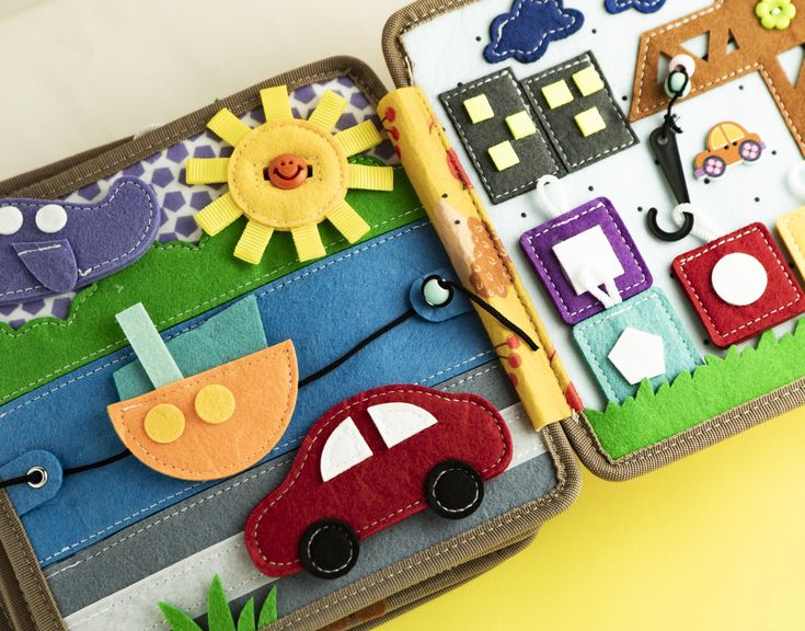 two children's suitcases decorated with magnets and felt pieces on yellow background