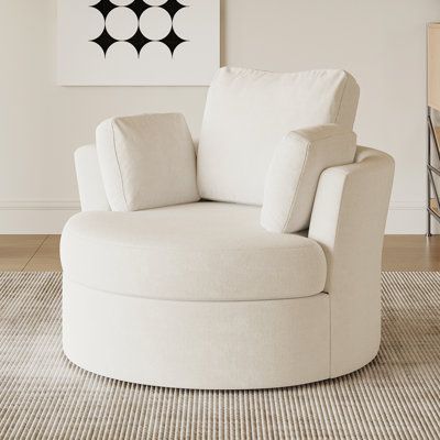 a white chair sitting on top of a rug in a living room next to a painting