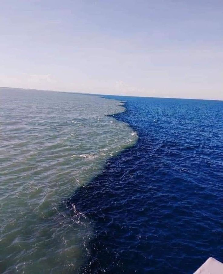 the water is very blue and there are waves coming in from the back of the boat