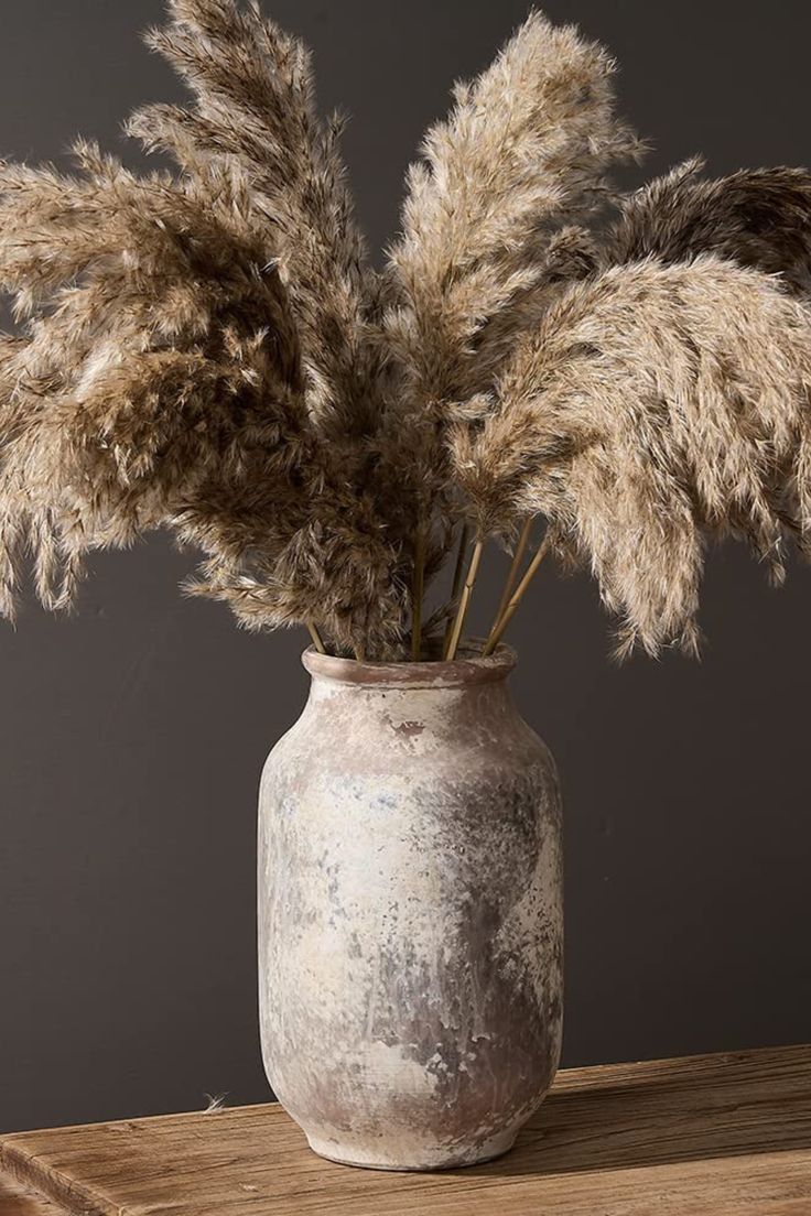 some dried plants in a vase on a table