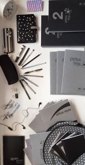 various office supplies laid out on top of a white table with black and white polka dots