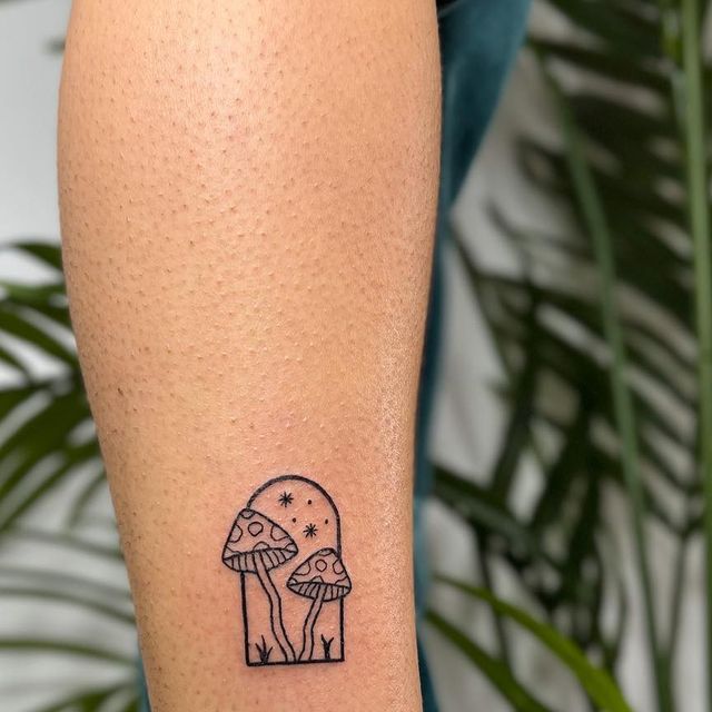 a small mushroom tattoo on the left calf area is shown in black and white ink