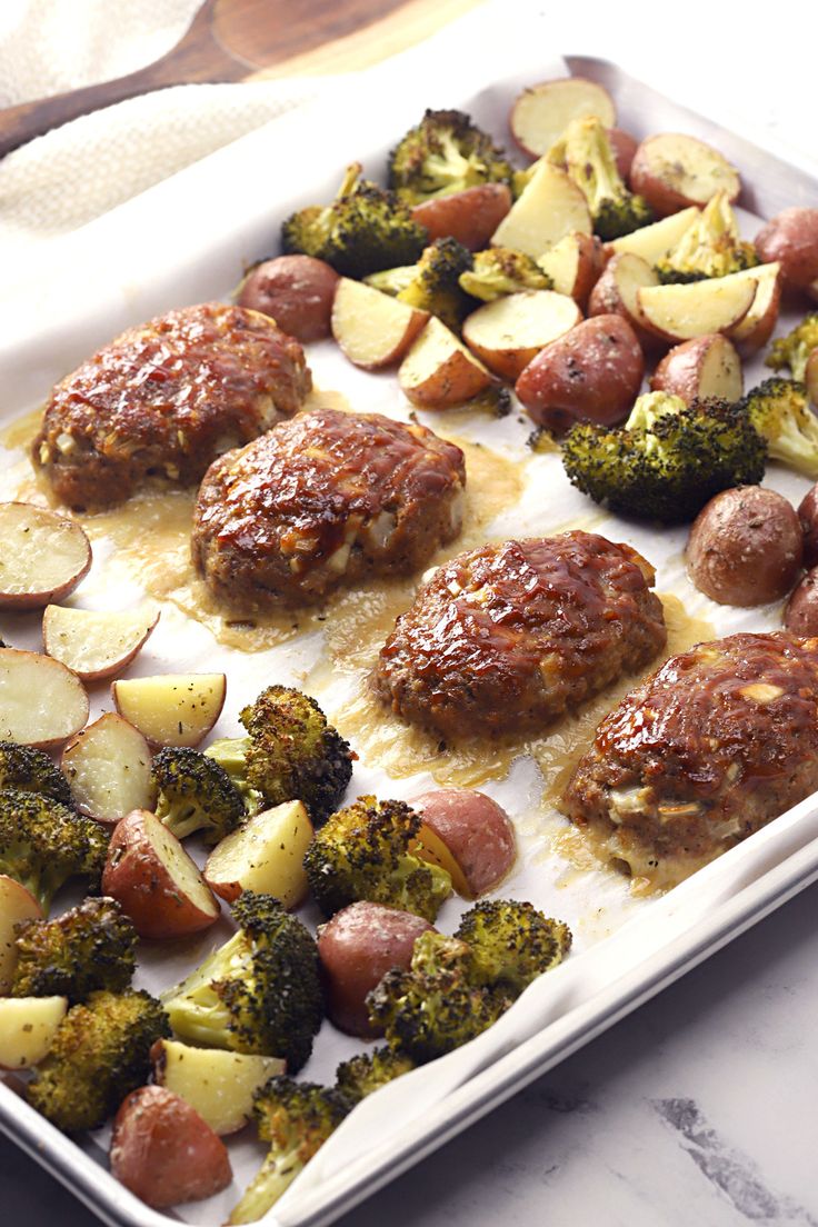 meatballs, potatoes and broccoli on a baking sheet