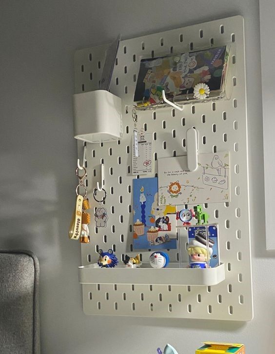 a white desk with various items on it and a lamp hanging from the wall above